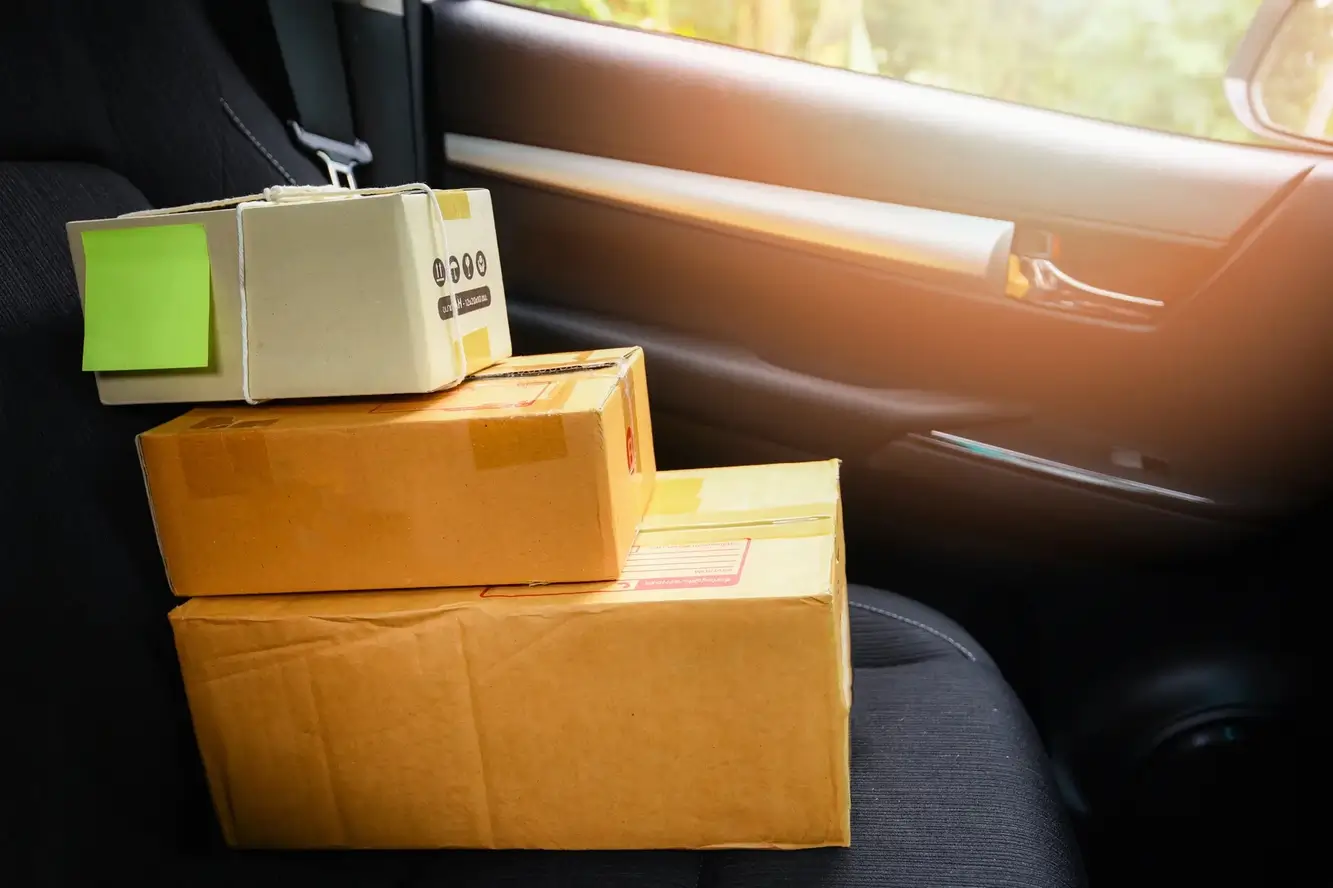 Boxes rest in the front seat of a delivery vehicle making Colorado B2B transportation services seamlessly simple.